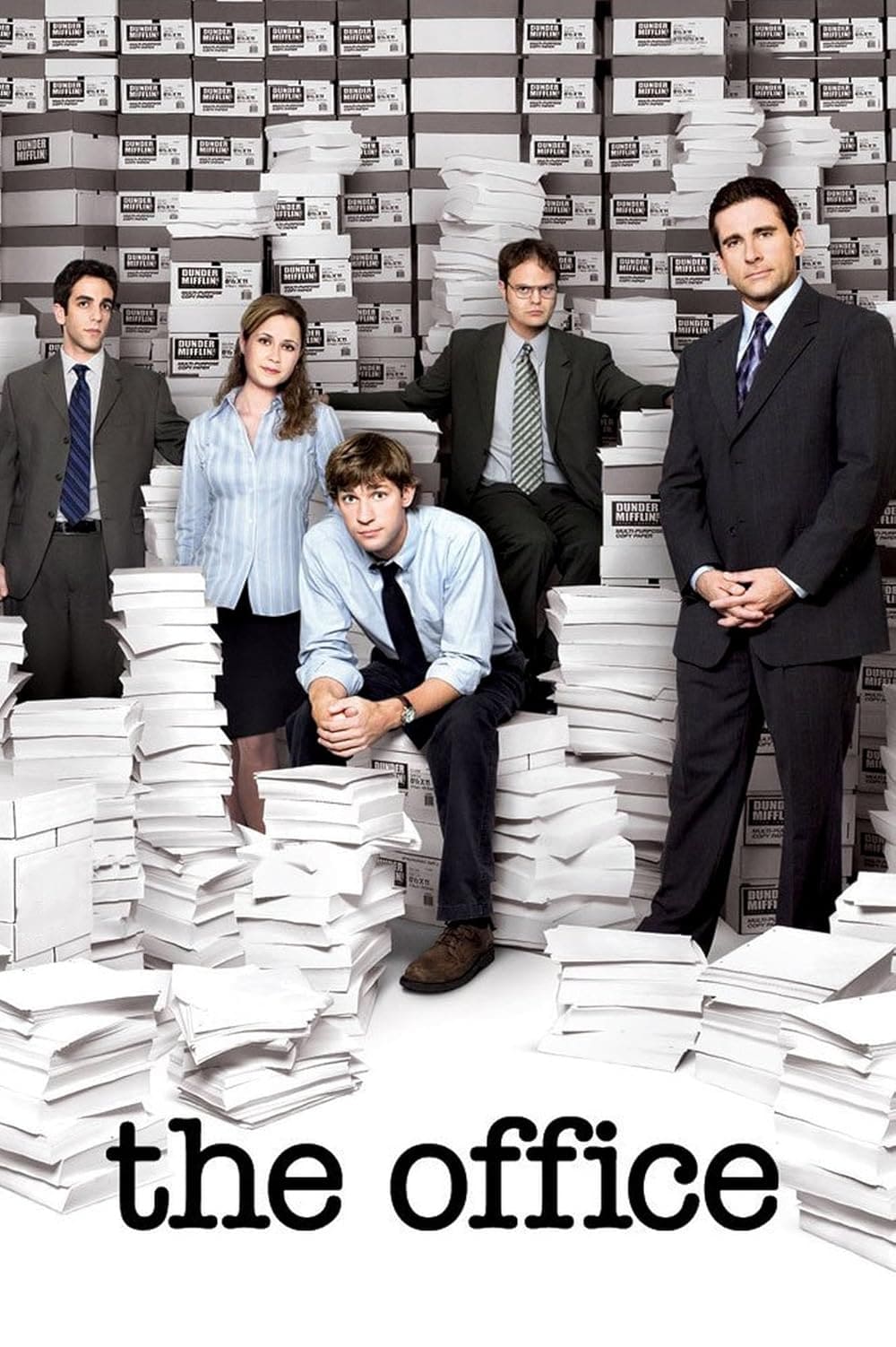 Five people in office attire stand or sit among tall stacks of paper and boxes labeled “white paper,” with a small screen in the background streaming Colombia IPTV. The words “the office” appear at the bottom in bold lowercase letters.
