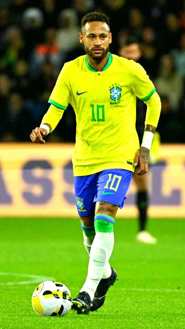 A soccer player in a yellow Brazil jersey with number 10 dribbles a ball on the field during a match, as excited fans stream the action through Colombia IPTV.