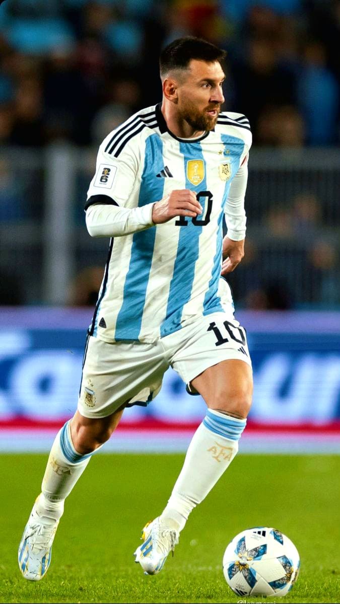 A soccer player in an Argentina jersey, number 10, runs on the field while controlling the ball during a match — all captured as if streamed live on Colombia IPTV. The background is blurred with stadium lights and fans visible.